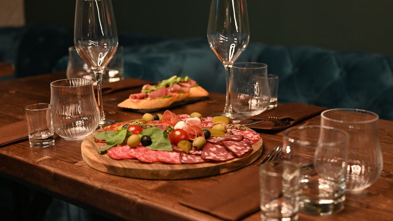 Planche de charcuteries et verres sur une table en bois