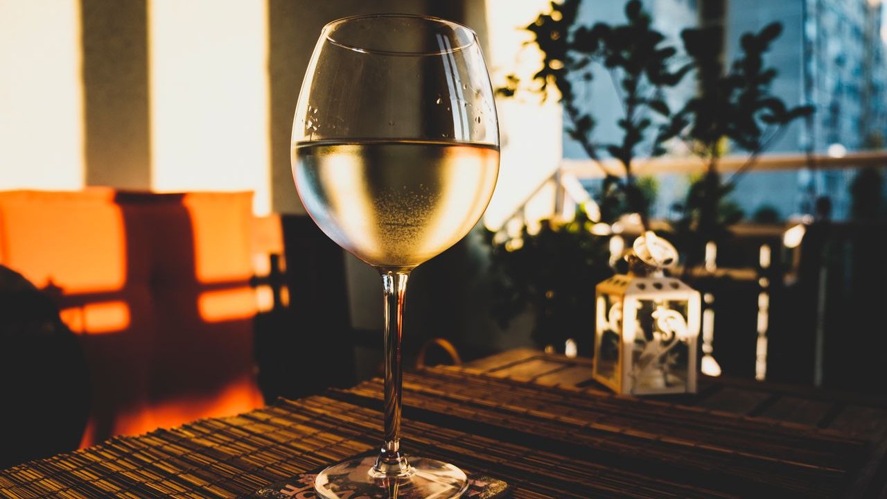 Verre de vin blanc posé sur une table en bois